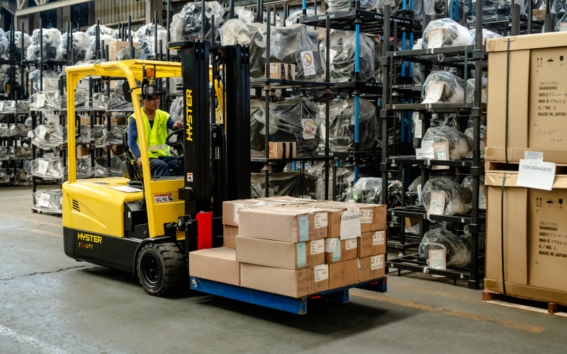Forklift technician topping up a lead-acid battery in a Singapore warehouse